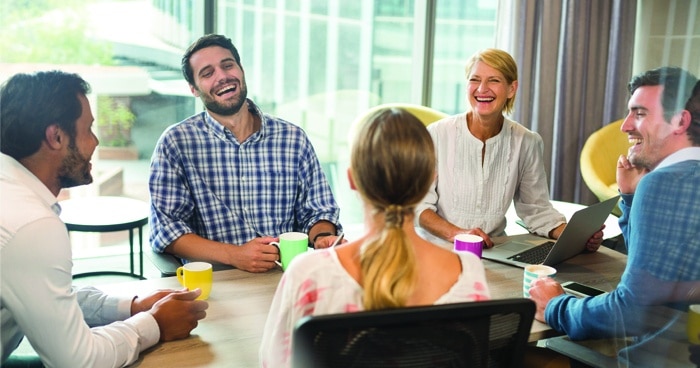 a-stock-photo-of-a-group-of-friends-laughing-around-the-table