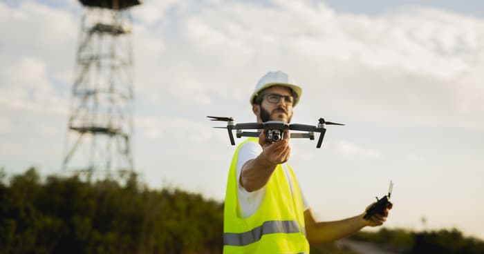 a-stock-photo-of-a-man-wearing-a-safety-vest-holding-a-drone