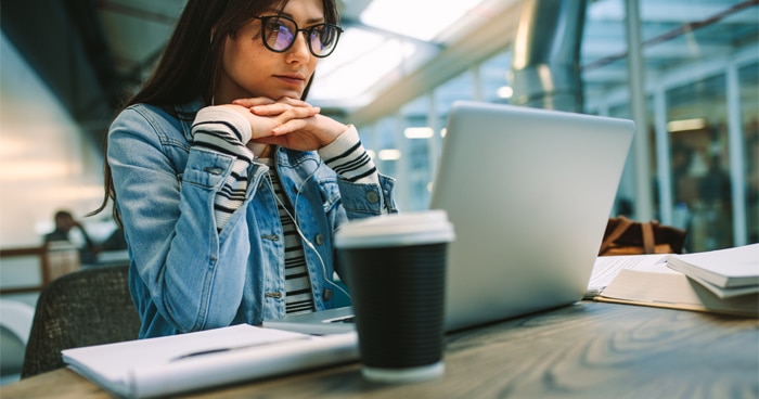 a-stock-photo-of-a-woman-sitting-at-a-desk-with-a-laptop-and-a-cup-of-coffee