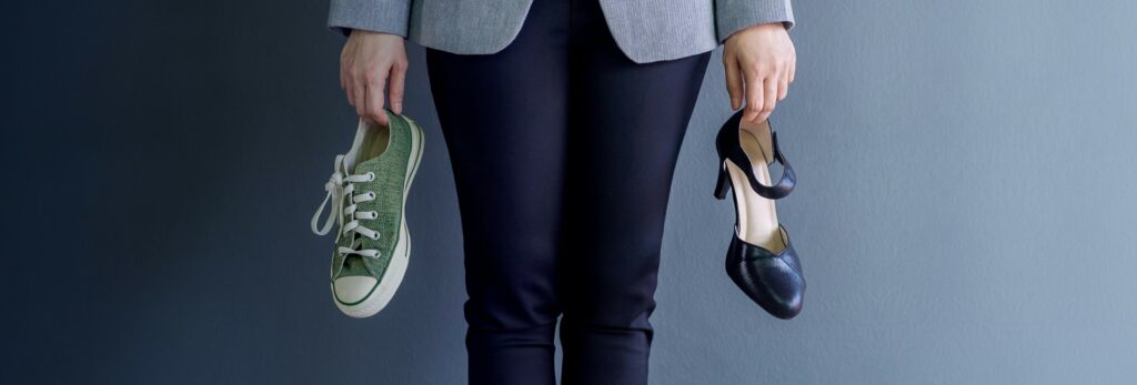 a-header-image-used-for-a-blog-post-which-features-a-woman-holding-two-sets-of-shoes-one-of-them-is-an-athletic-shoe-and-one-of-them-is-a-professional-shoe